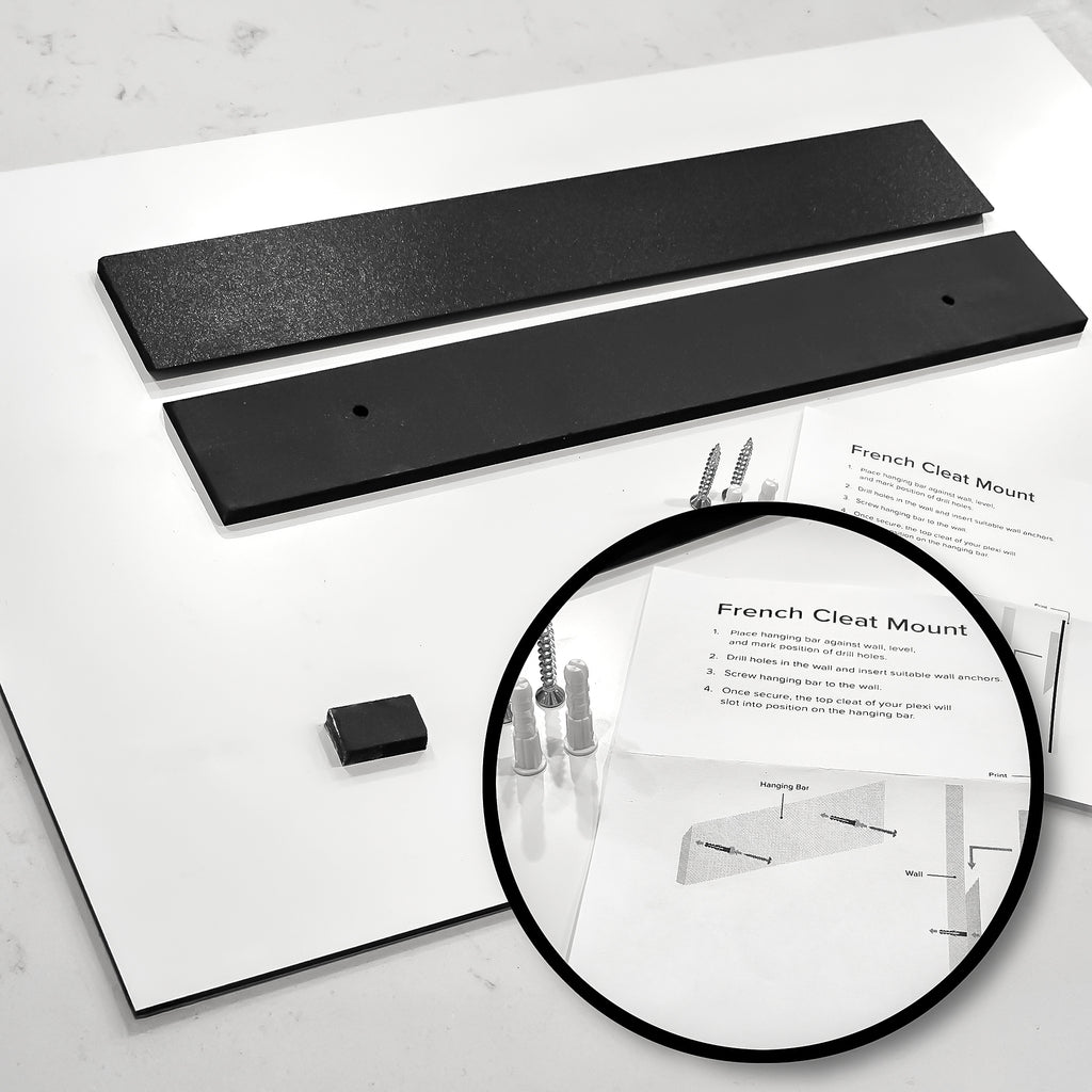 Two black metal brackets on a white surface with a magnifying glass highlighting text.